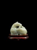 A CELADON JADE CARVING OF A RECUMBENT HORSE, China, 20th century