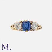 An Antique Sapphire and Diamond Three Stone Ring in yellow gold, set with a principal cushion cut