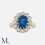 A Sapphire and Diamond Ring in 18K gold, set with an oval cut sapphire to the centre with round