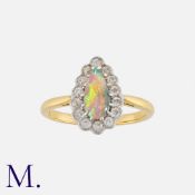 An Opal and Diamond Cluster Ring in 18 carat yellow gold, set with a pear shaped cabochon opal