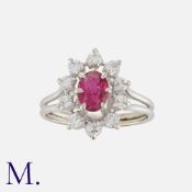 A Ruby and Diamond Cluster Ring in 18K white gold, set with an oval-cut ruby with round cut diamonds