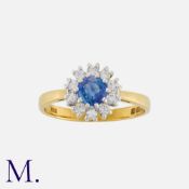 A Sapphire and Diamond Cluster Ring in 18 carat gold, set with a principal round cut sapphire within