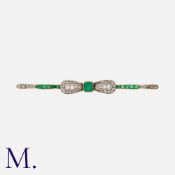 An Edwardian Emerald and Diamond Bow Brooch in yellow gold and platinum, set with step cut