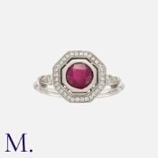 A Ruby and Diamond Cluster Ring in white gold, set with a round cut ruby of approximately 0.85