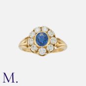 A Sapphire and Diamond Cluster Ring in yellow gold, set with an oval cut sapphire of approximately