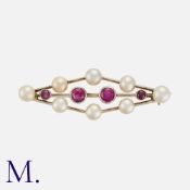 A Ruby and Pearl Brooch in white gold, of lozenge form, set with four round cut rubies and eight
