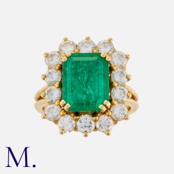 A Colombian Emerald and Diamond Ring in 18K yellow gold, set with an emerald-cut emerald weighing