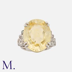 An Impressive Ceylon Yellow Sapphire and Diamond Ring in platinum, set with a large oval-cut
