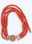 A four-strand necklace in blood coral style with a 14kt gold clasp, marked with an 'oak leaf', (one 