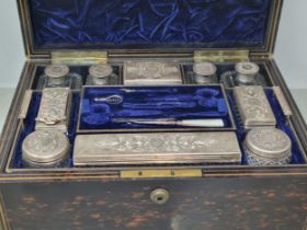 A Victorian coromandel Dressing Case containing silver lidded fittings with fine engraving and
