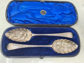 A pair of George III silver Berry Spoons with floral and fruit embossed bowls, engraved stems,
