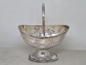 A Victorian silver oval Basket embossed ribbons and floral swags, swing handle on pedestal base,