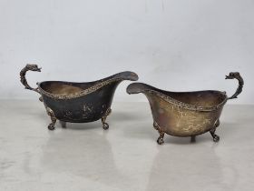 A pair of George VI silver Sauce Boats with Celtic friezes and mask handles on scroll feet,
