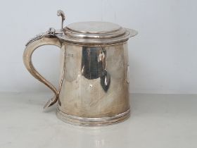 A George V silver Quart Tankard with flat hinged lid having volute thumb piece, scroll handle with
