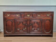 An 18th Century oak Dresser Base with three drawers over a pair of cupboard doors between panels,