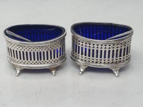 A pair of George V silver pierced oval Salts with blue glass liners, Chester 1920/2, plus Spoons,