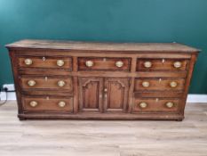An 18th century oak enclosed Dresser Base with cross-banded top above seven drawers surrounding pair