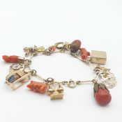 A vintage Charm Bracelet stamped 'A&W 9ct' (Alabaster & Wilson?) suspending a collection of