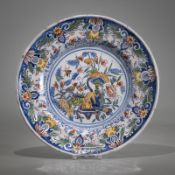 AN ASIAN STYLE FLORAL TOOLED FAYENCE PLATE