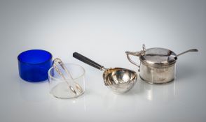 A JAM POT WITH SPOON AND A TEA STRAINER