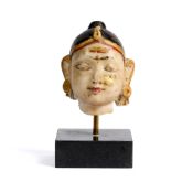A SMALL PAINTED MARBLE HEAD OF A DEITY, RAJASTHAN, 19TH CENTURY