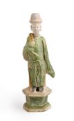 A CHINESE GREEN AND AMBER-GLAZED ATTENDANT, MING DYNASTY, 15/16TH CENTURY