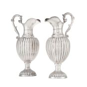 Paire d'aiguières en argent 800, Espagne, XXe s., à décor de godrons, les anses feuillagées, lestés