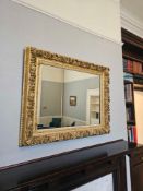 Large ornate wall mirror in carved wood and gilt gesso frame. Richly moulded with scrolling acanthus