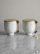 A pair of ice bucket sets crafted from honed white marble, likely Carrara, each with a circular