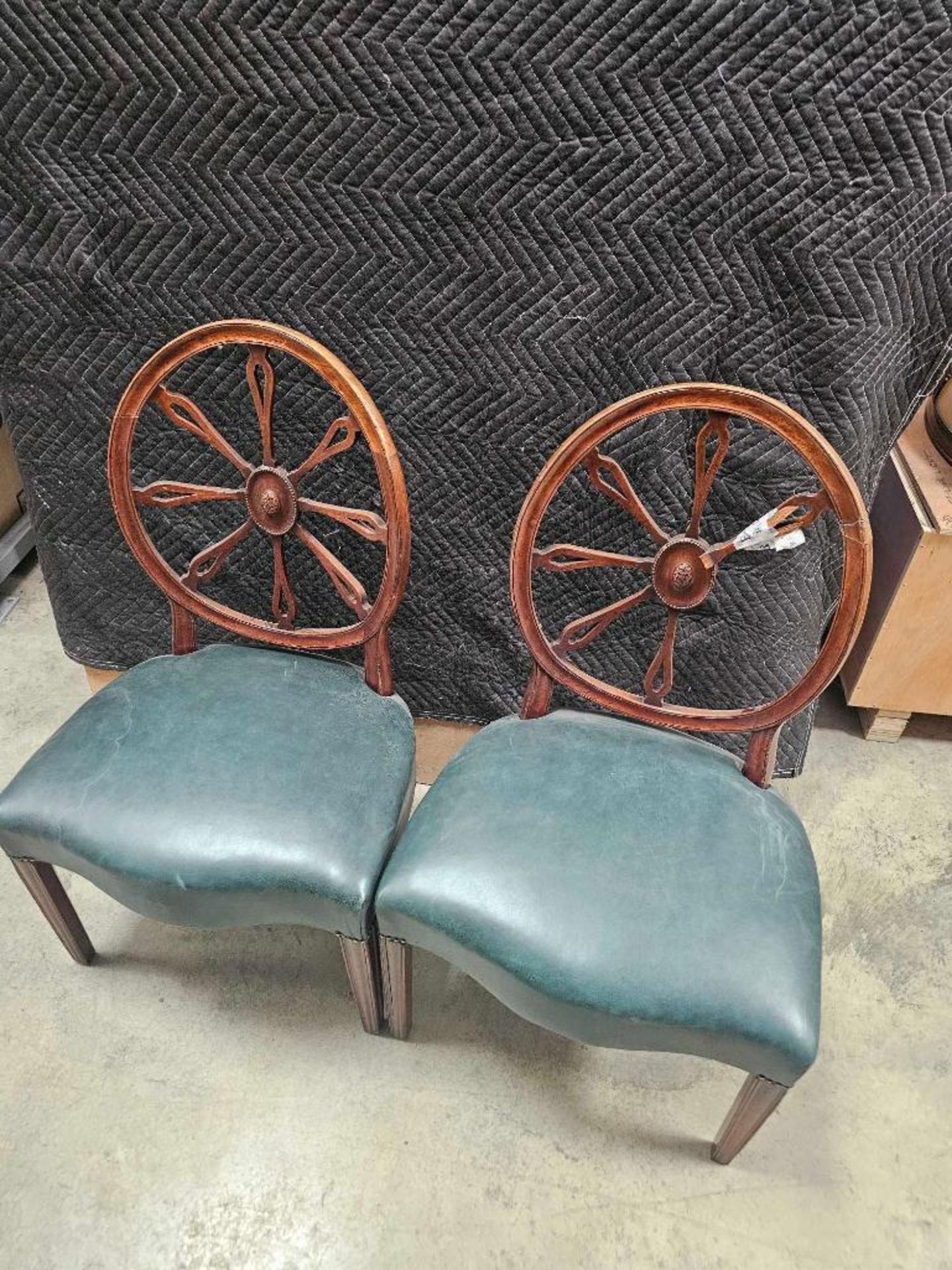 Pair of George III style wheelback chairs features circular backrests with central carved medallions