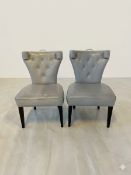 A pair of Hollywood Regency style side chairs with dramatic flared backrests upholstered in smooth