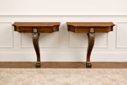 A pair of mahogany ormolu-mounted wall consoles, each featuring a single elegantly curved support