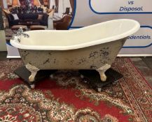A white cast‑iron freestanding roll‑top slipper bath, raised on classic claw‑and‑ball feet, offering
