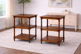 A pair of three-tier mahogany-finish side tables, featuring a classic open-shelf design with