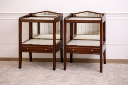 A pair of mahogany nightstands featuring a galleried top with a shaped mirror plate inset,