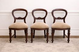 A set of three mahogany Victorian balloon-back chairs featuring a classical open-back design