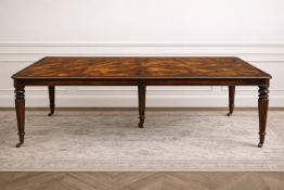 A William IV style extending mahogany dining table featuring a substantial, flame-grained tabletop