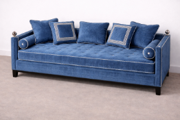 A neoclassical style blue velvet daybed featuring a deep-buttoned tufted seat pad accented with