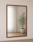 A large cherrywood framed mirror featuring a substantial rectangular mirror plate within a