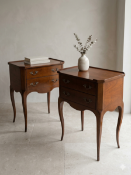 A pair of 20th-century French-style cherrywood bedside or end tables featuring a raised gallery edge