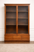 A Victorian hardwood display cabinet featuring a large two-door glazed upper section with slender