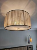 A modern 3-light flush mount ceiling fixture featuring a translucent fabric drum shade with a