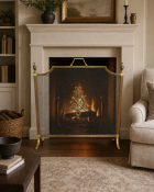 A French style brass spark guard featuring a decorative arched frame with an integrated carrying