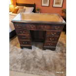 A twin-pedestal desk in the Georgian style, featuring a rectangular top inset with a tan leather