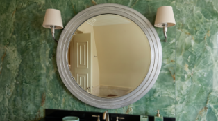 A Contemporary Circular Silver-Lacquered Stepped Mirror features a substantial circular timber frame
