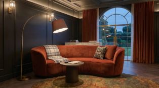 A contemporary terracotta rust crescent-shaped curved sofa, expertly upholstered in premium velvet