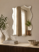 A contemporary frameless wall mirror, measuring approximately 60 x 80cm, featuring a distinctive and