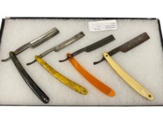 FOUR ANTIQUE SINGLE BLADE STRAIGHT RAZORS BAKELITE, FRENCH IVORY, HORN, AND MARBLED HANDLES