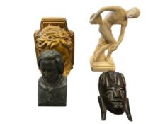 FOUR COLLECTIBLE FIGURINES INCLUDING CARVED WOOD TRIBAL FACE, H. DE BALZAC RESIN BUST, AND MORE