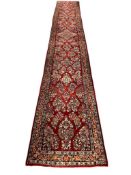 MID-20TH CENTURY HAND WOVEN WOOL PILE PERSIAN SAROUK LONG HALLWAY RUNNER RUG WITH VIBRANT RED COLOR